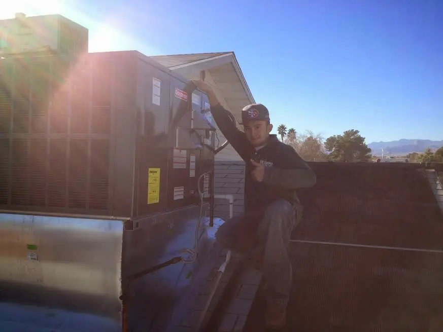 HVAC technician performing AC Tune-Up on a rooftop unit in Pike Road